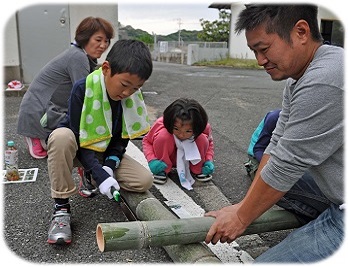 ノコギリで竹を切っている写真です