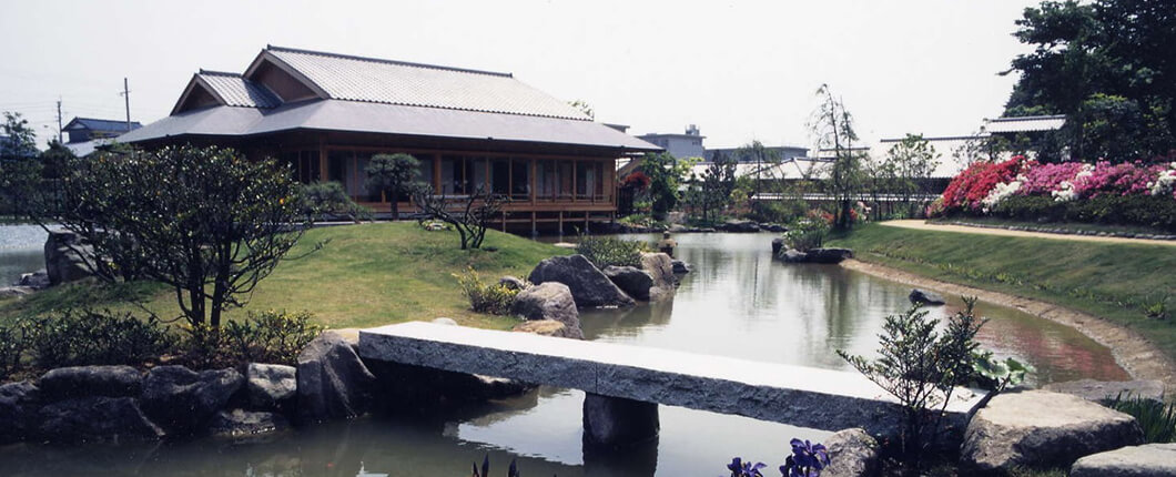 建物と庭園の写真　池には石の橋が架かっている