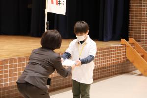 小学生が修了認定証を受け取っている写真です