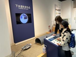 キッズが下水管検査ロボットの操縦体験を行っている写真です。