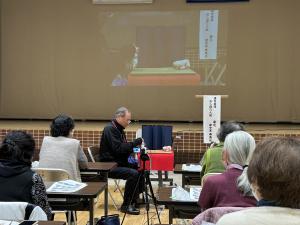 講師がおしぼり人形を躍らせている写真です。