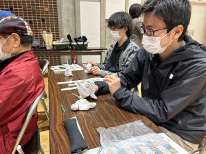 参加者がおしぼり人形を躍らせている写真です。