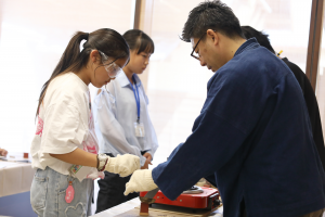 鋳物印鑑づくりで錫を流しこんでいる写真です。
